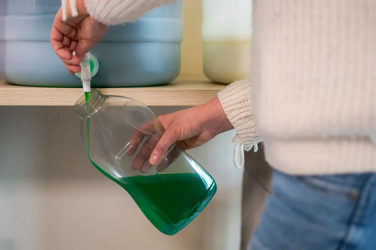woman refilling detergent bottle